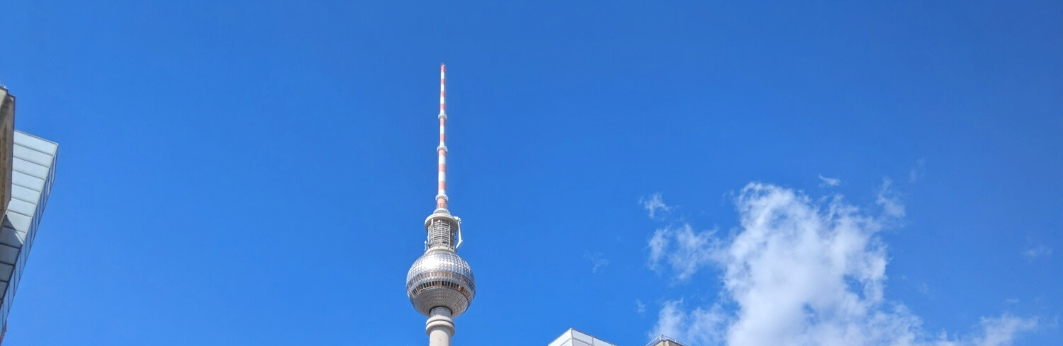 Im Bild die Spitze des Fernsehturms am Alexanderplatz in Berlin vor blauem Himmel