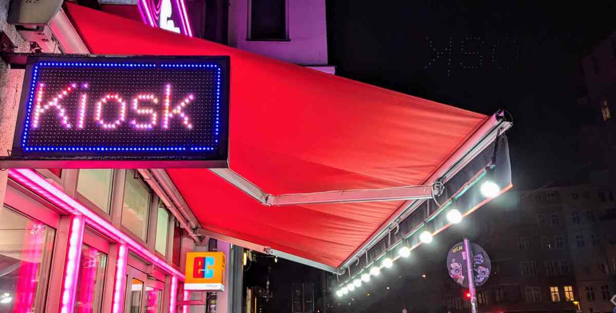 Bild von einem Kiosk in der Nacht mit schöner Leuchtschrift