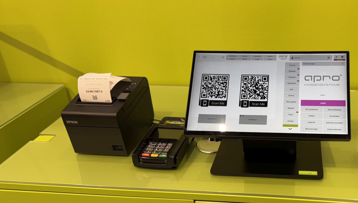 im bild ist ein kassensystem von apro (hardware) aufgebaut. man sieht einen qr code auf dem bildschirm.