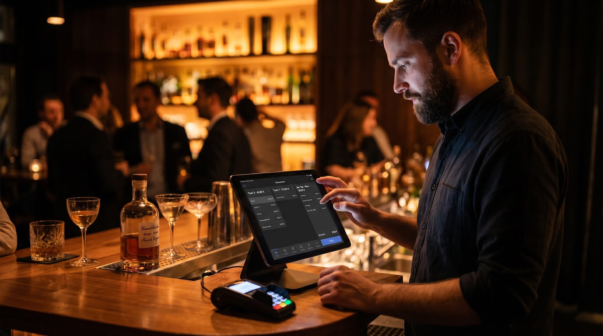 Bartender in dunklem Hemd bedient Tablet-Kassensystem an der Bar mit deutschem Bar-Tab-Interface, Tisch 3, Tisch 7 und Bar Tab Max sichtbar, Spirituosenflasche und Cocktailgläser auf dem Tresen, warme Amber-Beleuchtung mit Gästen im Hintergrund